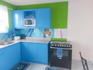 cocina azul con fogones y microondas en Grateful #2 - 1bd B, en Bridgetown