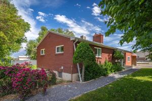 una casa de ladrillo rojo con flores en el patio en Lazy P Ranch House, en Taylorsville