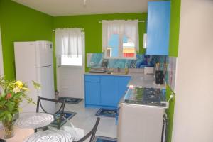 cocina con paredes azules y verdes y nevera blanca en ZenBreak Grateful #2 - 2bd A, en Bridgetown
