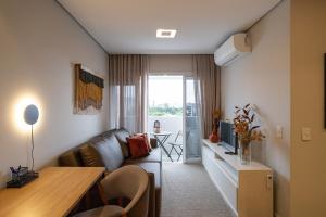 a small living room with a couch and a table at Apto 2qts, Ar Condicionado, Piscina, Churrasqueira, Finamente Mobiliado e Decorado in Curitiba