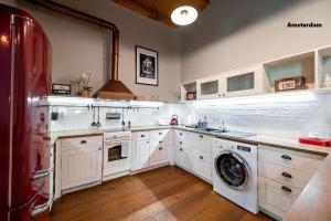 a kitchen with white cabinets and a washer and dryer at Amsterdam Vintage Industrial Style in Košice