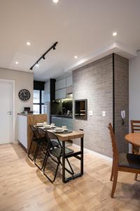 a kitchen and dining room with a table and chairs at Apto 2qts, Ar Condicionado, Piscina, Churrasqueira, Finamente Mobiliado e Decorado in Curitiba