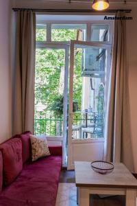 a living room with a purple couch in front of a window at Amsterdam Vintage Industrial Style in Košice