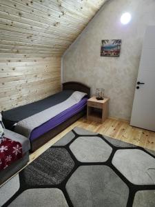 une chambre avec un lit et un tapis dans l'établissement Villa Monte relax, à Žabljak