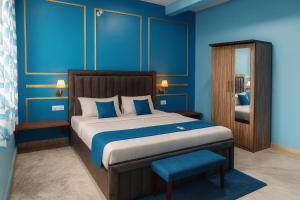 a bedroom with a large bed with blue walls at Kashivas - 2BHK near Assi Ghat in Varanasi
