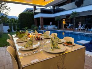 a table with plates of food on it next to a pool at Villa SONNE in Antalya