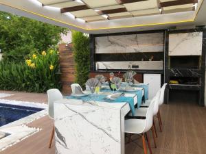 a dining room with a blue table and white chairs at Villa SONNE in Antalya