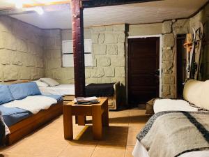 a room with two beds and a table in it at Hostal Cabaña Farellones in Santiago