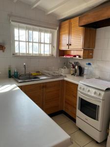 a kitchen with a white stove and a sink at Hostal Cabaña Farellones in Santiago