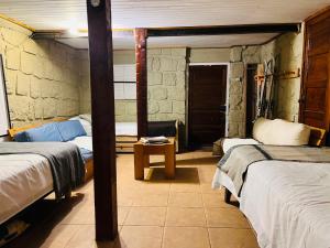 a room with three beds and a table in it at Hostal Cabaña Farellones in Santiago +6 photos