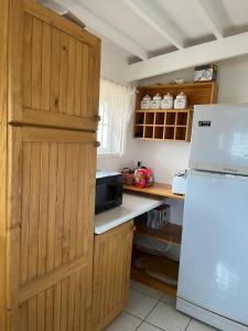a kitchen with wooden cabinets and a white refrigerator at Hostal Cabaña Farellones in Santiago