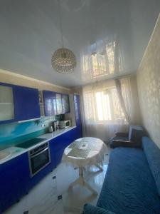 a kitchen with blue cabinets and a table in a room at Odessa Pearl Apartment in Odesa