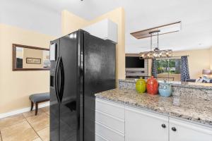 a black refrigerator in a kitchen with a counter at Fairway View Escape - For 8 in Branson