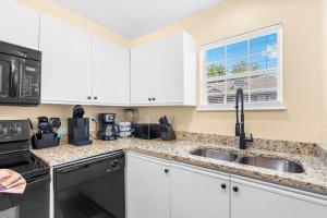a kitchen with white cabinets and a sink at Fairway View Escape - For 8 in Branson +16 photos