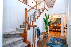 una escalera en una casa con paredes blancas y suelo de madera en The Bayside Villa, en Bradenton