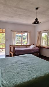 a bedroom with a bed and two windows at Terrazas San Pedro in San Pedro