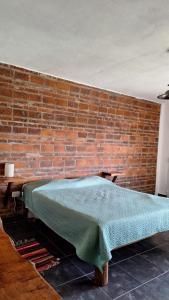 a brick wall with a bed in front of it at Terrazas San Pedro in San Pedro