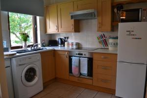 a kitchen with a washing machine and a refrigerator at Boat Green Apartment in Edinburgh