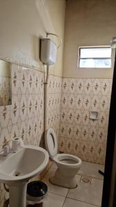 a bathroom with a toilet and a sink at Hotel Bandeirantes de Juina in Juína