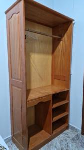 a wooden cupboard with ajar doors and shelves at Hotel Bandeirantes de Juina in Juína