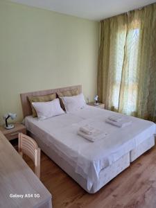 a bedroom with a large bed with two towels on it at JULY MORNING SEAside HOTEL in Kavarna +15 photos