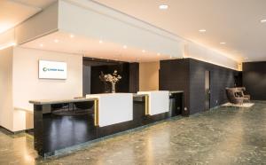a lobby with a reception desk and a table at Ilunion Pio XII in Madrid