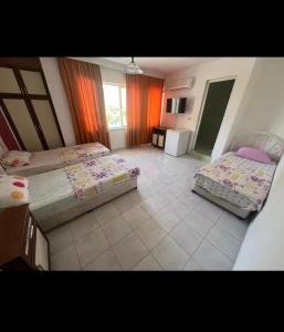 a bedroom with two beds and a tiled floor at Onur Motel in Bozdoğan +8 photos