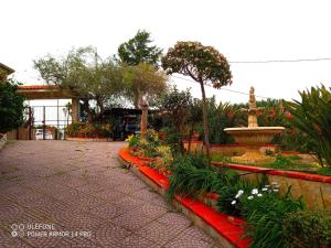 a garden with a fountain and a courtyard with flowers at Apartment in Villa Sea Horizon Sand Beach in Cefalù