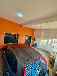 a car parked in a garage with an orange wall at Distrito Ananindeua in Ananindeua