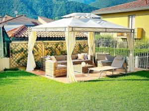 un gazebo blanc avec un canapé et des chaises en dessous dans l'établissement Eleganza e comfort - Lago d'Iseo, à Paratico