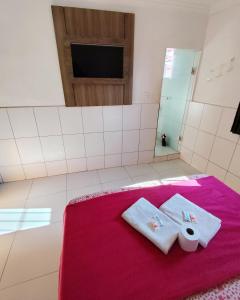 une salle de bain avec deux serviettes sur une couverture rose dans l'établissement Hotel Lalique, à São Paulo