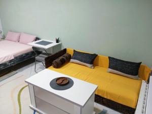 トゥズラにあるTuzla Stay Apartmentの黄色いソファとテーブルのあるリビングルーム