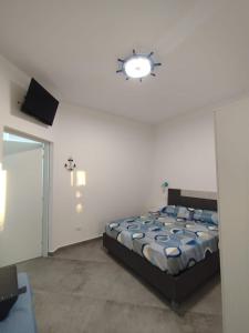 a bedroom with a bed and a light on the wall at Camere d'a mare in Capo dʼOrlando +28 photos