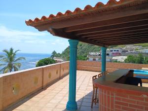 a patio with a table and a view of the ocean at Casa Cerdeña in Puerto Carayaca +13 photos