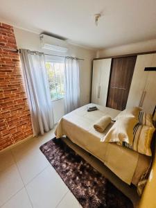 a bedroom with a large bed and a brick wall at Casa Cataratas in Foz do Iguaçu