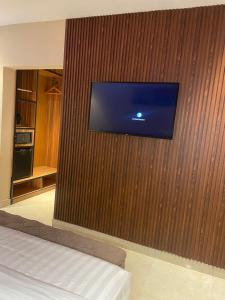 a flat screen tv on a wooden wall at Axion Hotel in Owerri