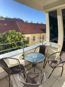 Un patio con sillas y una mesa en un balcón. en Quiet Central Stay & Parking Assistance, en Praga