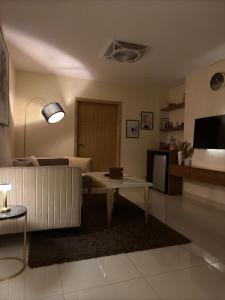 a living room with a couch and a table at Skyluxe Designer Suites with rooftop Pool, Gym, Sauna & Self Check In in Islamabad