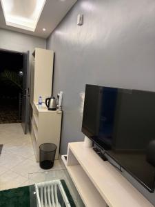 Una sala de estar con un televisor de pantalla plana grande. en Klassroom Hostelry, en Kampala