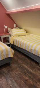 a bedroom with two beds and a night stand at Slapen bij Ticho in Yerseke