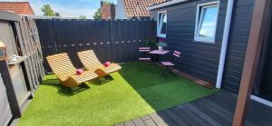 a small backyard with two chairs and a table at Slapen bij Ticho in Yerseke