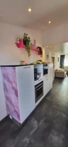a kitchen with white cabinets and a purple counter top at Slapen bij Ticho in Yerseke