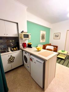 a kitchen with a washer and dryer in a room at The Artist's Nook - Syntagma Escape in Athens +3 photos