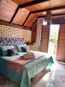 a bedroom with a large bed with a wooden ceiling at Pousada Rio da Prata in Blumenau