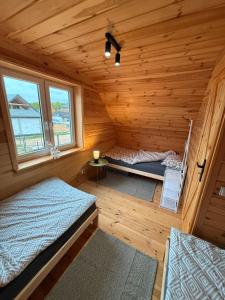 a room with two beds in a log cabin at #Fuleda#Giżycko Fuledzianka domek na Mazurach #bania #jacuzziklimat in Giżycko