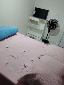a bedroom with a pink bed with flowers on it at Casa aconchegante in Castro