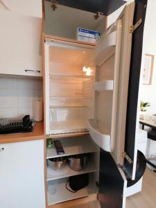an empty refrigerator with its door open in a kitchen at 2 Schlafplätze - Zentral, ruhig, WLAN, Terrasse in Bocholt