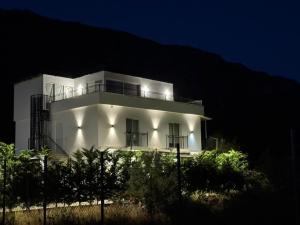 a white building with lights on it at night at Calm & Green Retreat in Baks-Rrjoll