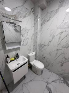a white bathroom with a toilet and a sink at Calm & Green Retreat in Baks-Rrjoll +22 photos