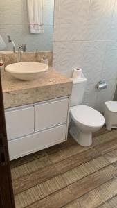 a bathroom with a toilet and a sink at Casa de Praia em Jaua in Camaçari